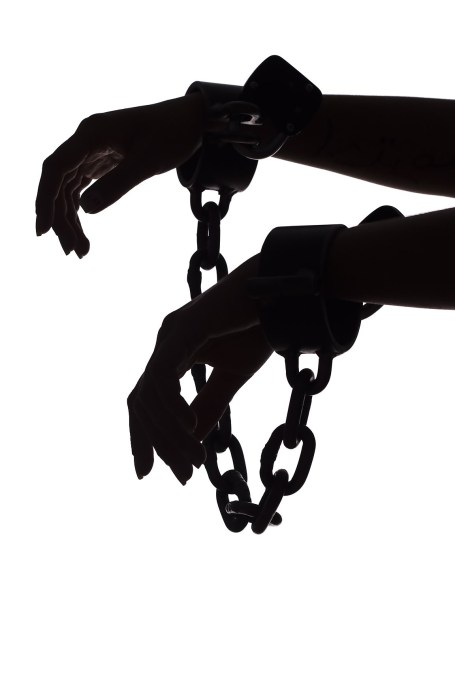 silhouette of woman's hands with chains